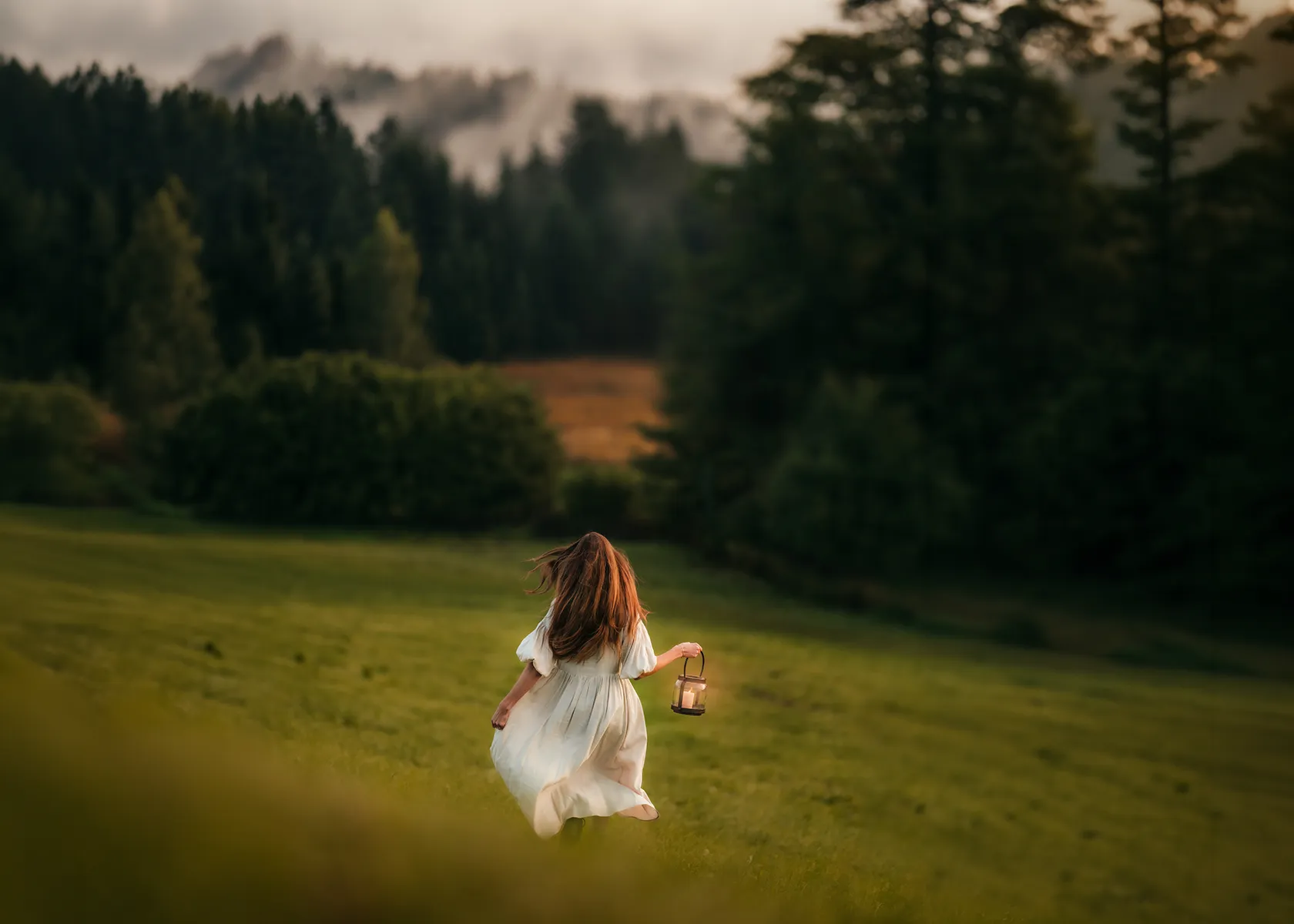 eine Frau läuft mit einer Laterne in der Hand über eine Wiese