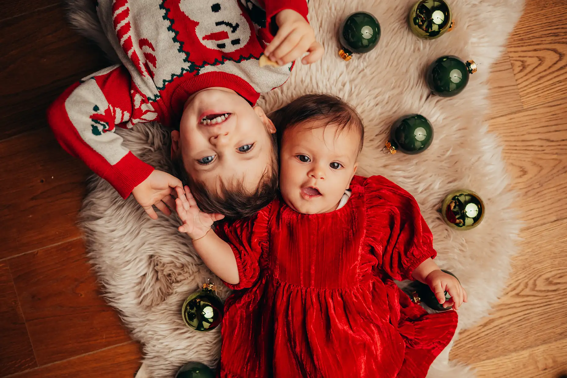 Kinder umringt von Weihnachtskugeln, Fotoidee